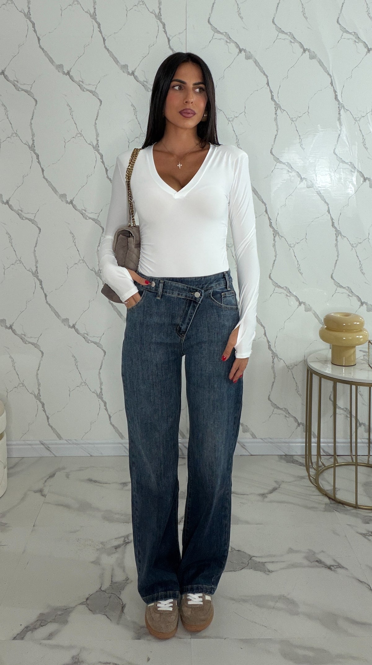 Jeans con bottone asimmetrico
